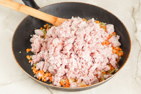 Мясной фарш, выложенный к обжаренным овощам в сковороде