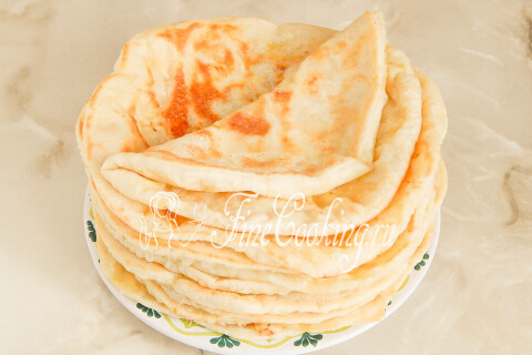 Готовые лепёшки с сыром, сложенные стопкой на тарелке