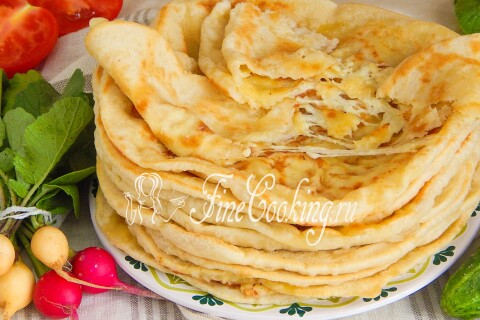 Мягкие ароматные лепёшки с сыром в стопке на столе