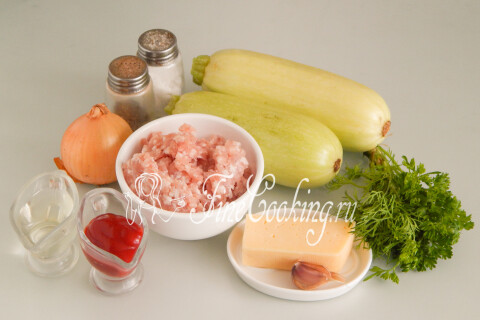 Продукты для лодочек из кабачков: кабачки, мясной фарш, лук, томатный соус, сыр, чеснок и зелень.