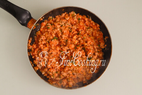 Готовая мясная начинка с овощами и зеленью в сковороде.