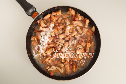 Мясо с грибами и мукой, залитое кипятком в сковороде.