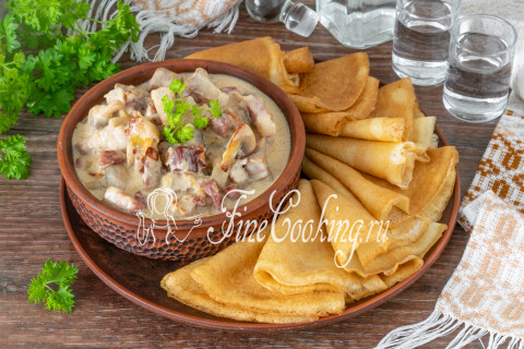 Тарелка с блинчиками и мясным соусом мачанка, поданная горячей к обеду.