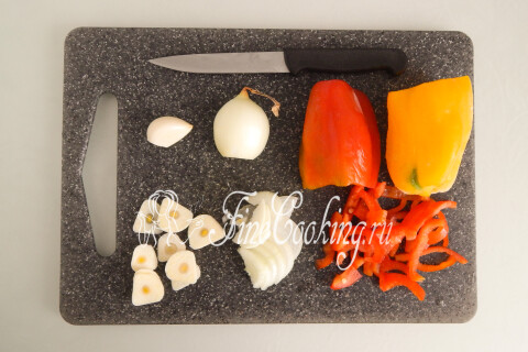 Сладкий перец соломкой, лук полукольцами и чеснок пластинами на разделочной доске