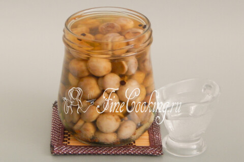 Уксус наливается в банку с грибами и рассолом столовой ложкой.