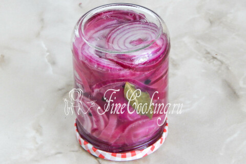 Банка с маринованным луком закрыта крышкой и укутана пледом