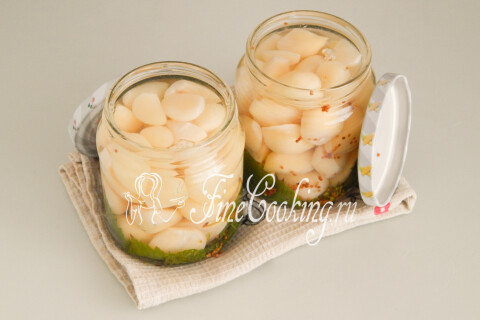Банки с чесноком, залитые горячим маринадом до кромки.