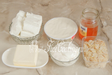 Продукты для медовой пасхи: творог, сливочный сыр, сметана, мёд, сливочное масло и миндальные лепестки.