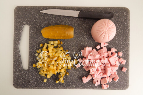 Варёная колбаса и маринованные огурцы, нарезанные мелким кубиком.