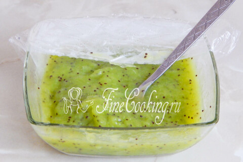 Миска с массой мороженого из киви в морозильной камере, разбитая вилкой