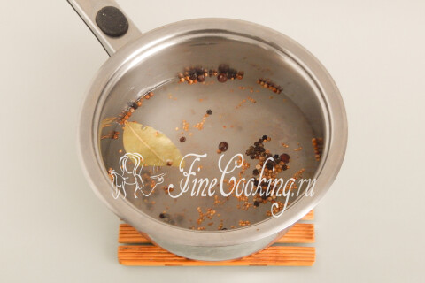 Кастрюля с водой, солью, сахаром, семенами горчицы, перцем горошком, гвоздикой и лавровым листом на плите.