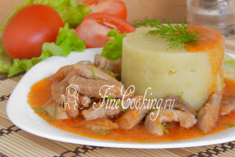 Тарелка с мясной подливой и картофельным пюре на столе