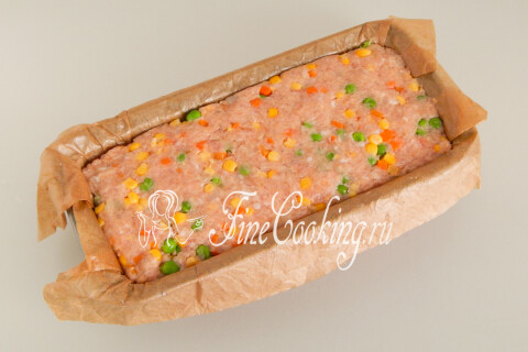 Фарш для мясного хлеба, уложенный и уплотнённый ладонью в форме для выпечки.