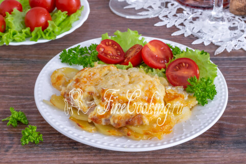 Порция мяса по-французски на тарелке со свежей зеленью