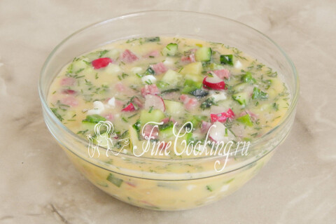 Тарелка окрошки на квасе с несколькими кубиками льда сверху.
