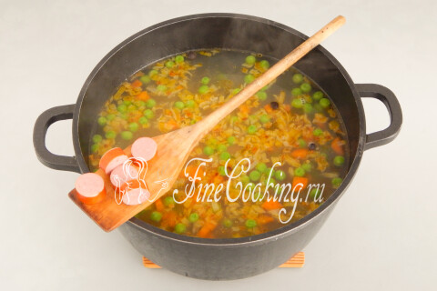 Кружочки сосисок в кастрюле супа с овощами и картофелем