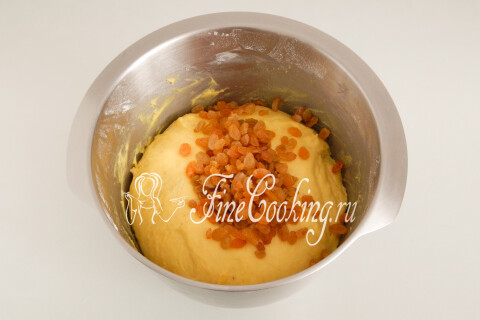 Промытый и обсушенный изюм рядом с подошедшим сдобным тестом.
