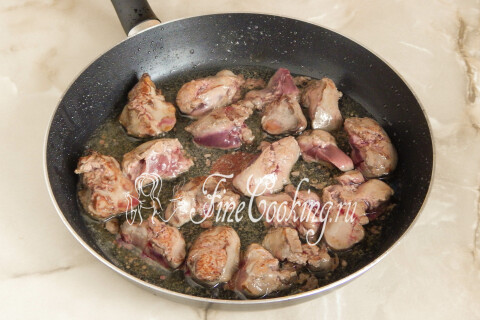 Куриная печень, обжариваемая кусочками в глубокой сковороде до румяной корочки