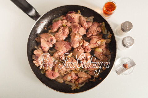 Обжаренная печень с луком, коньяком, мускатным орехом и чёрным перцем в сковороде.