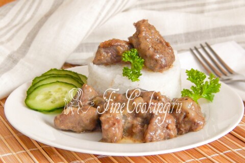 Ломтики печени с луком в сметанном соусе, поданные с овощами и зеленью