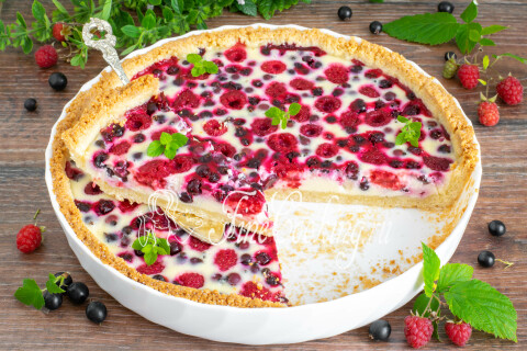 Готовый песочный пирог с малиной и черной смородиной, разрезанный на куски