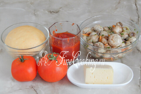 Продукты для пиццы с шампиньонами: тесто, маринованные шампиньоны, томатный соус, помидоры и сыр
