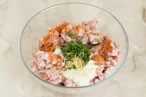 Рубленая зелень и тёртый репчатый лук поверх мясного фарша в миске.