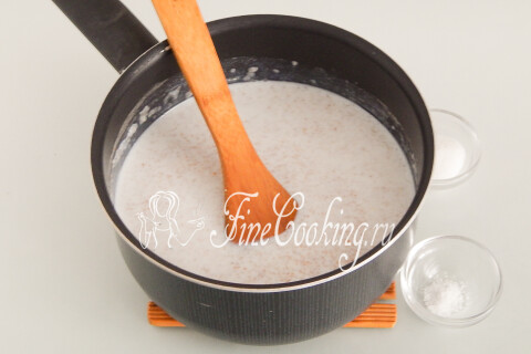 Каша с добавленными сахаром и солью, помешиваемая ложкой в кастрюле.