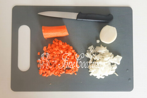Морковь и репчатый лук нарезаны мелким кубиком на разделочной доске.