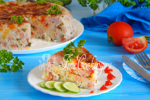 Рисовая запеканка с ветчиной и сыром, поданная со свежими овощами и зеленью.