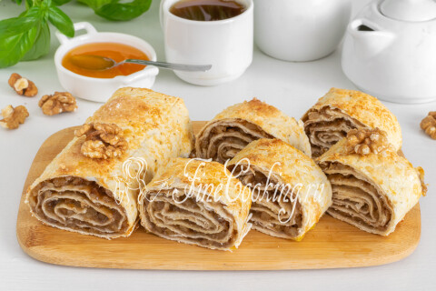 Нарезанные порционными кусочками рулеты из лаваша на доске.