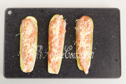 Тёртый сыр, посыпанный поверх курицы на кабачковой полоске