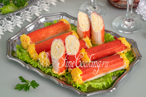 Охлаждённая закуска из крабовых рулетиков с сырной начинкой на тарелке.