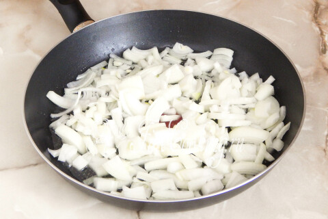 Нарезанный репчатый лук на разогретой сковороде с маслом