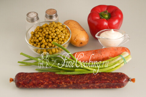 Копчёная колбаса, консервированный горошек, сладкий перец, картофель, морковь, зелёный лук и майонез на столе