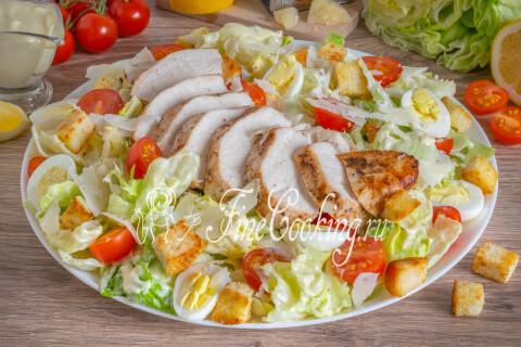 Салат Цезарь с курицей на блюде, готовый к подаче на праздничный стол.