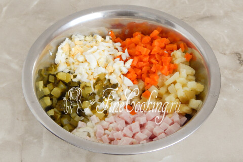 Морковь, картофель, яйца, ветчина, солёные огурцы и лук в глубокой миске.