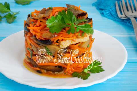 Порция салата с баклажанами, мясом и морковью по-корейски на тарелке