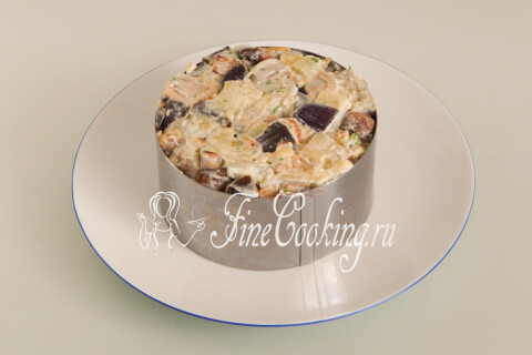 Плоская тарелка с салатом, выложенным с помощью кулинарного кольца
