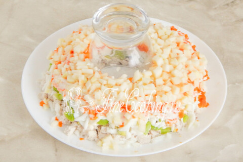 Кубики кисло-сладкого яблока, уложенные поверх моркови и выровненные руками.