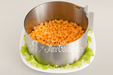 Слой консервированной кукурузы на дне разъёмного кольца.
