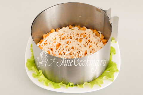 Сеточка майонеза поверх слоя кукурузы в разъёмном кольце.