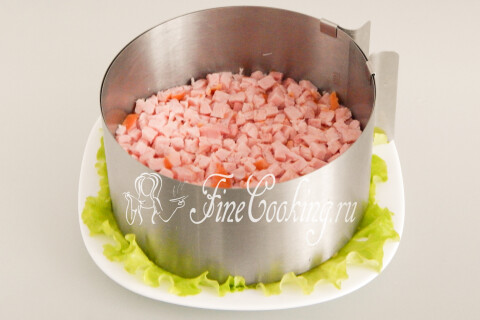 Слой кубиков ветчины поверх кукурузы с майонезной сеточкой.