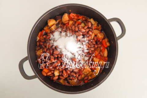 Сахар и соль, всыпанные в кастрюлю с овощами и фасолью