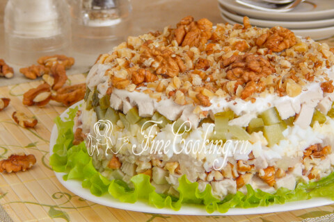 Слоёный салат с курицей и орехами на праздничном столе.