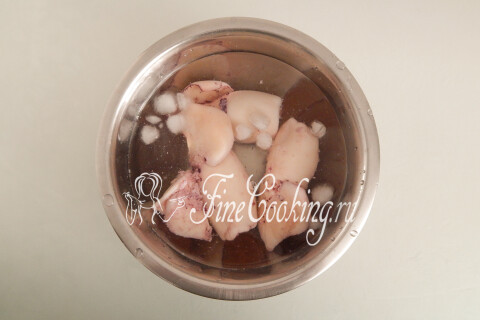 Варёные кальмары в миске с ледяной водой для снятия кожицы