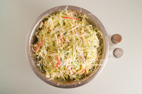 Салат с капустой и крабовыми палочками, заправленный майонезом.