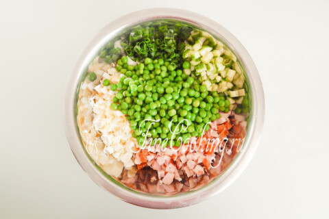 Копчёная курица, варёные яйца, огурцы и зелёный горошек в общей миске.