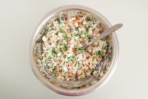 Салат с копчёной курицей и овощами в миске после перемешивания.
