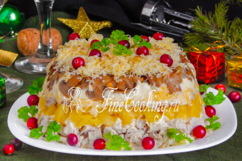 Готовый салат с курицей, ананасами, сыром и грецкими орехами на праздничном столе